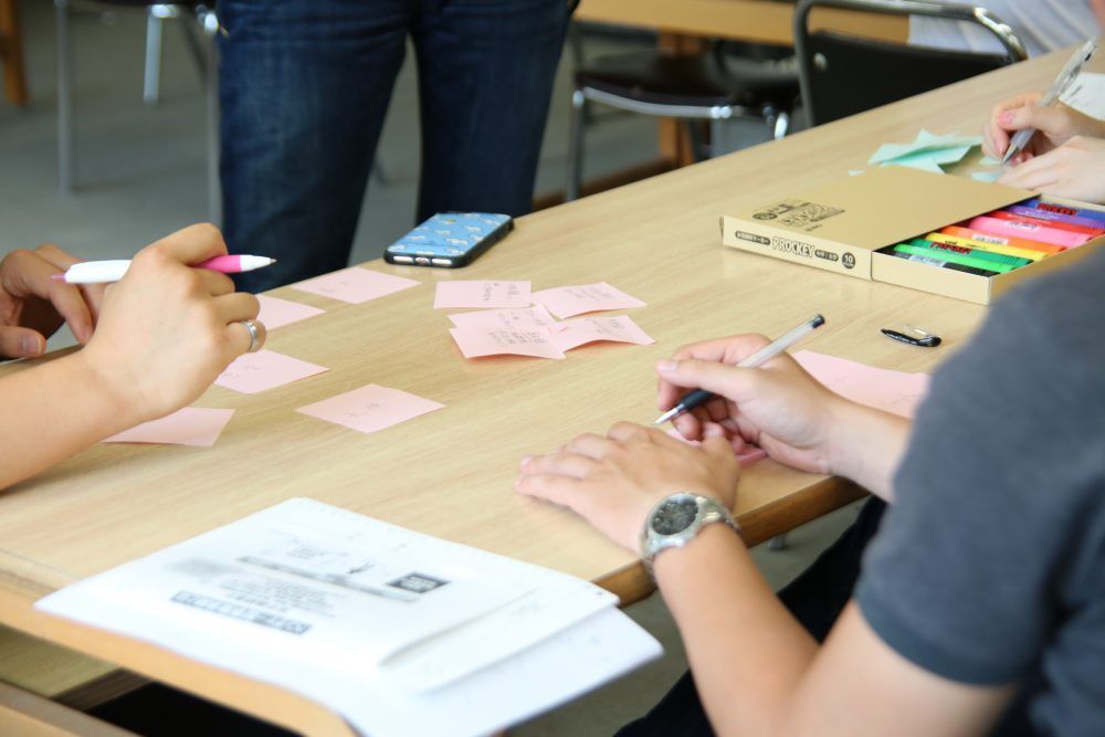ワークショップで付箋にアイデアを書き起こしていく学生たち